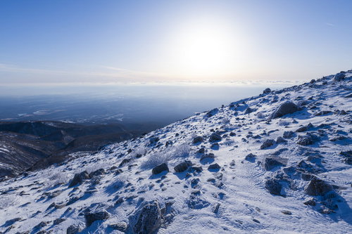 朝日が照り付ける那須茶臼岳の雪山斜面、冬の登山風景