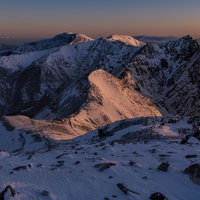 朝焼けに染まる雪の那須連山（那須岳）の成層火山の写真