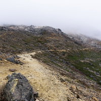 硫黄の香りが漂う那須岳中腹の火山性岩場の登山道の写真