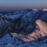 赤く燃える朝焼けの那須連山と遠くに見える飯豊山の写真