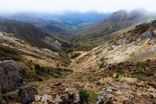 那須岳の裂けた谷間と成層火山の中腹に広がる紅葉
