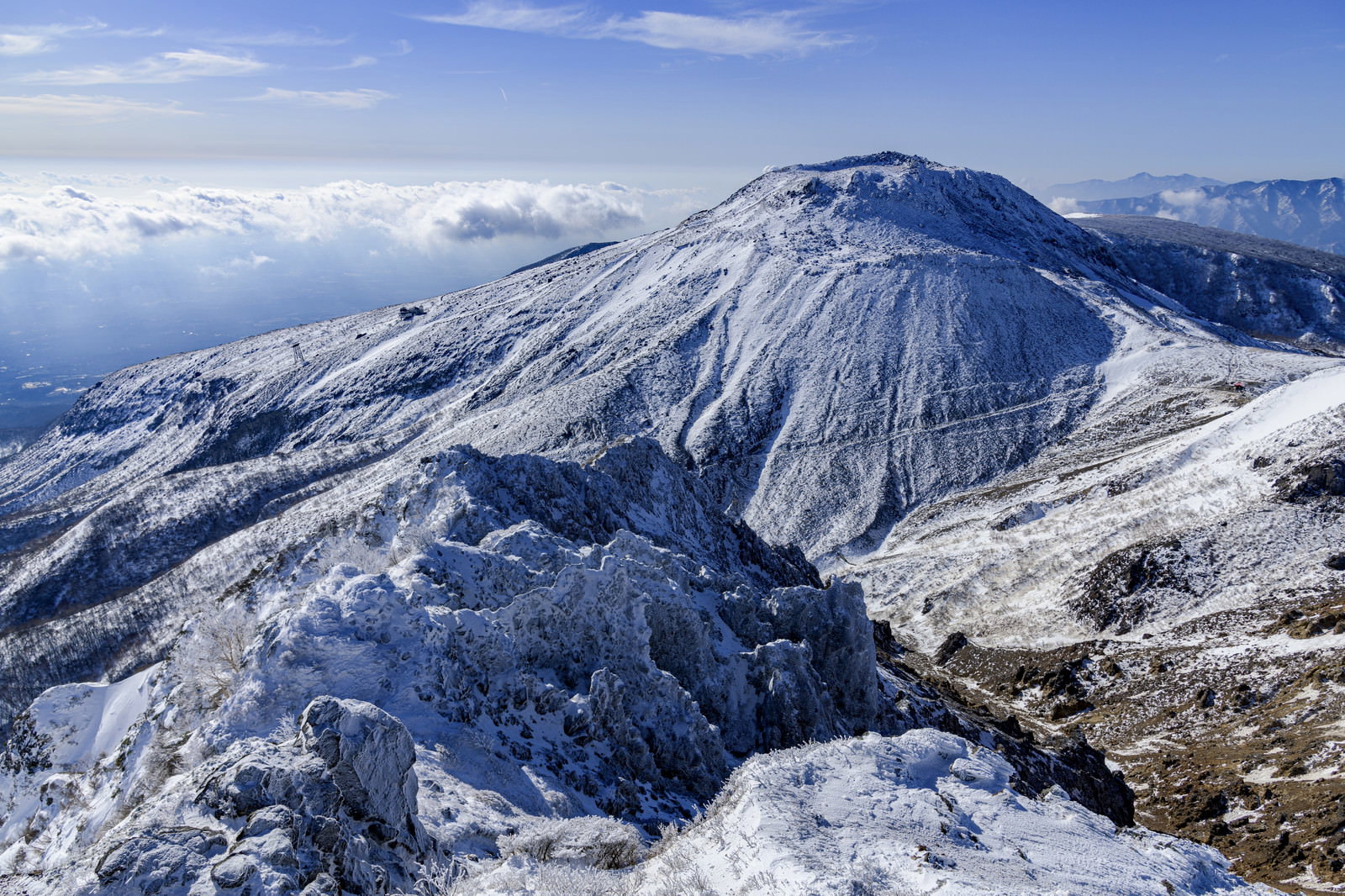 雪化粧した那須茶臼岳を那須朝日岳から望む冬の山岳風景