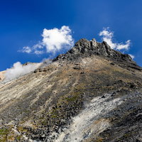 隆起した火山らしい見た目の那須茶臼岳（ちゃうすだけ）の山容の写真