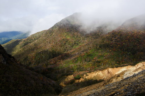 雲の隙間から色づく那須岳の紅葉と成層火山の秋景色