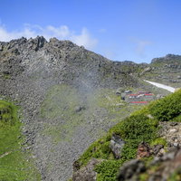 外輪から見る鳥海山山頂と山小屋の写真