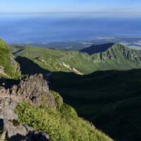 鳥海山の外輪山ピークから見る日本海と緑の山々の写真