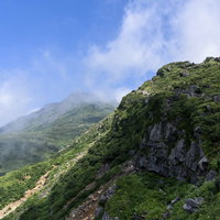 雲が流れ込む鳥海山山頂の写真