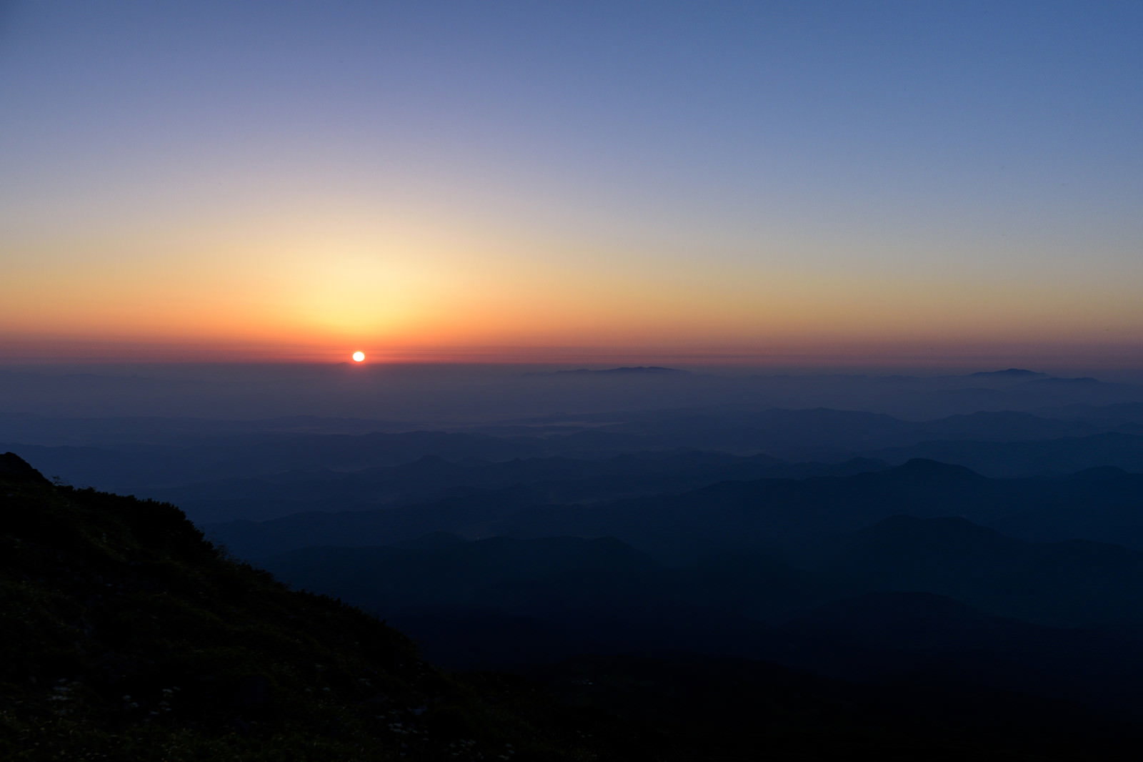 鳥海山の東から昇る朝日と朝焼けに染まった空