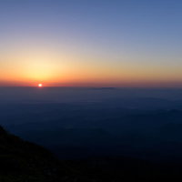 鳥海山の東から昇る朝日と山頂のシルエットの写真