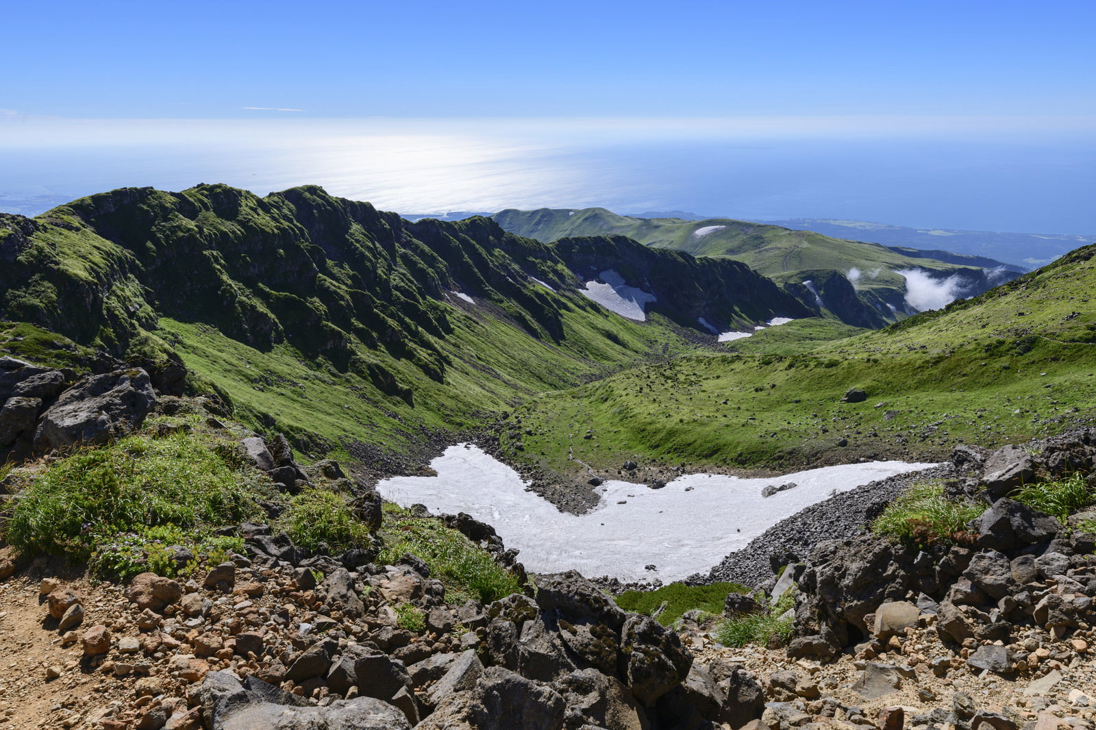 鳥海山の外輪山稜線と遠くに広がる青い日本海の山岳風景