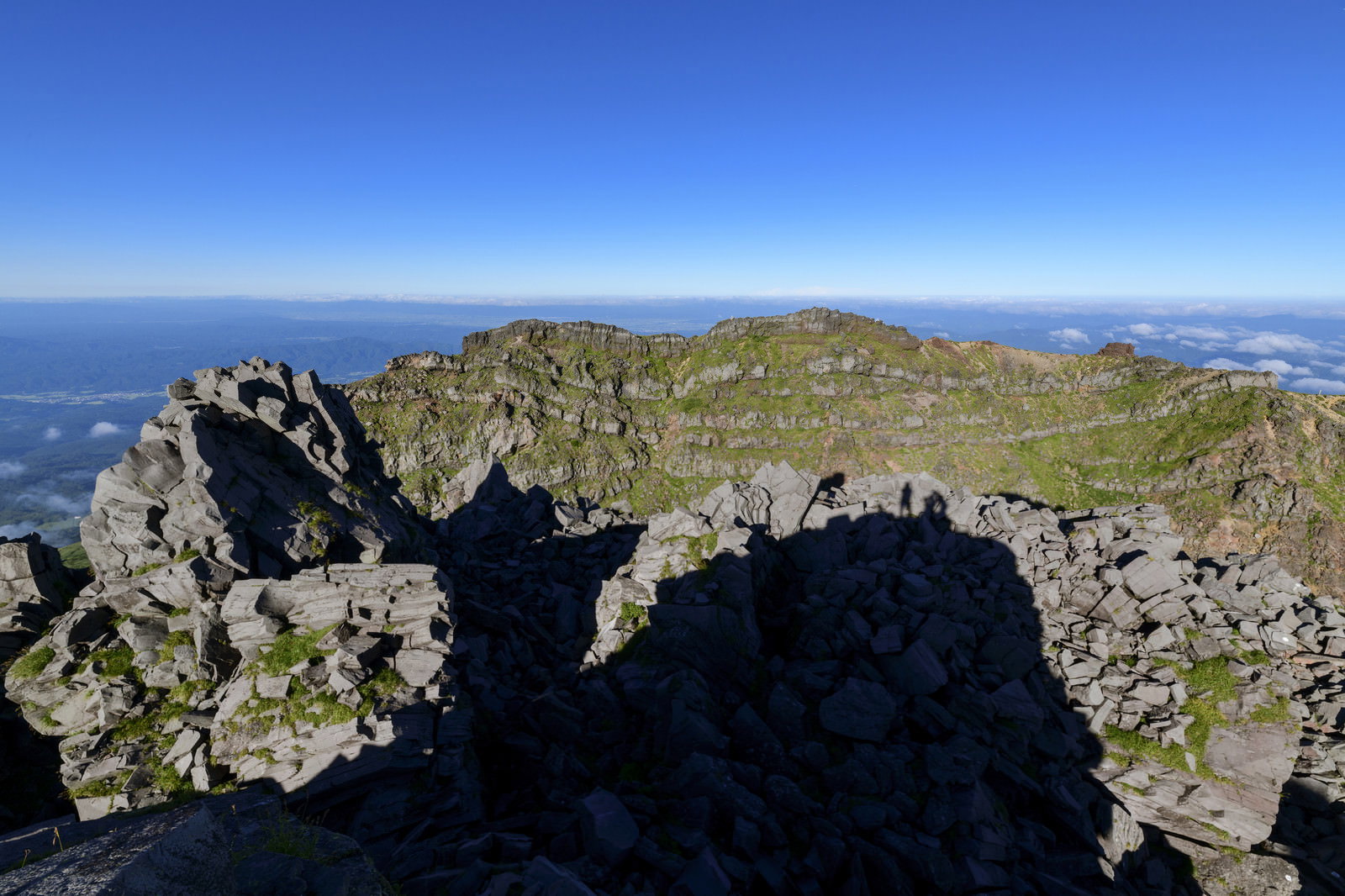 鳥海山の外輪山頂から見た岩場と東の地平線の風景
