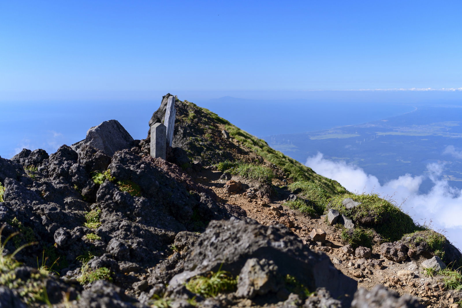 鳥海山外輪七高山の岩場に立つ石碑と雲海の景色