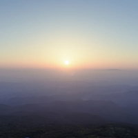 鳥海山山頂で迎えるエモい日の出、雲海と朝焼けのシルエットの写真