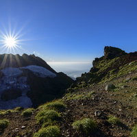 鳥海山山頂に落ちていく西日と放射状の光芒の写真