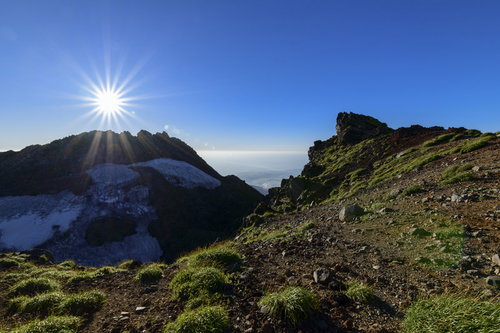 鳥海山山頂に落ちていく西日と放射状の光芒