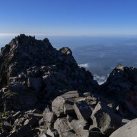 鳥海山山頂新山からの岩場と水平線の景色、雲海を望む登山風景の写真