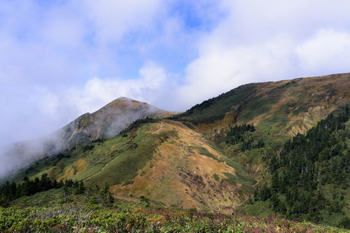 雲がかかる割引山と巻機山の稜線 日本百名山の山並み