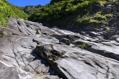 悠久の水の流れで削られた滑沢の岩（巻機山のヌクビ沢）