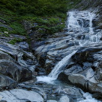 岩場がつづくヌクビ沢登山道の景色、苔むした岩と渓流（巻機山）の写真