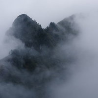 濃い霧とガスに包まれる巻機山の天狗岩の秋の登山風景の写真