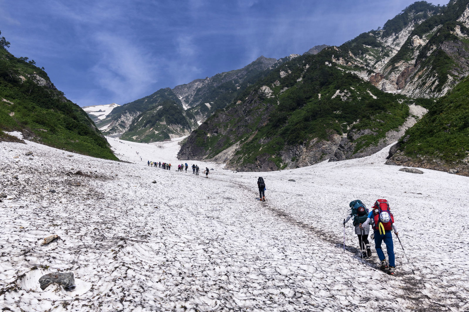 白馬大雪渓の急斜面を列で登る登山者たち
