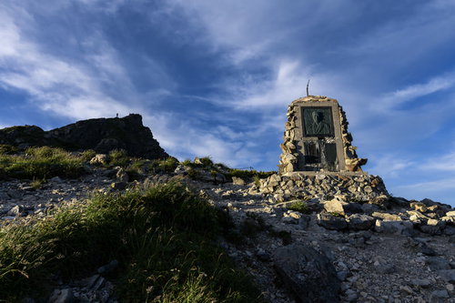 白馬岳山頂の石碑に刻まれたレリーフと青空