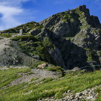 白馬岳山頂の岩肌と登山者の景色 北アルプスの雄大な山々を背景にの写真