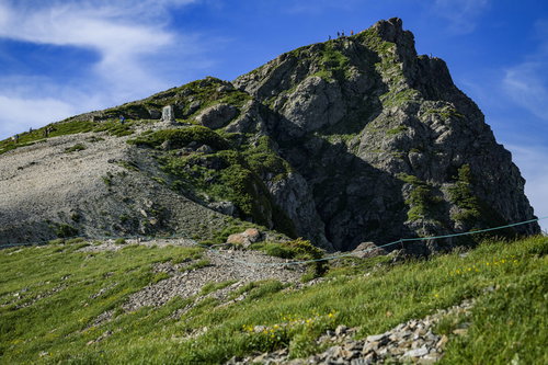 白馬岳山頂の岩肌と登山者の景色 北アルプスの雄大な山々を背景に