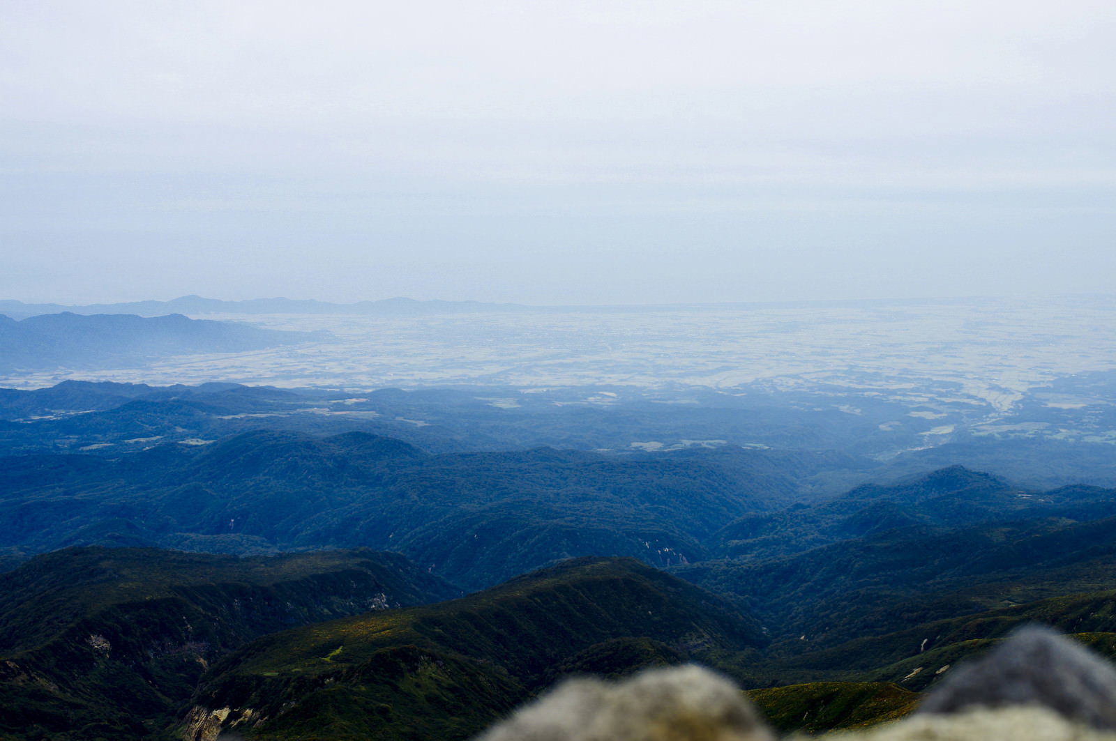 月山山頂から見下ろす庄内地方の山々の遠景、青空と重なる山稜線