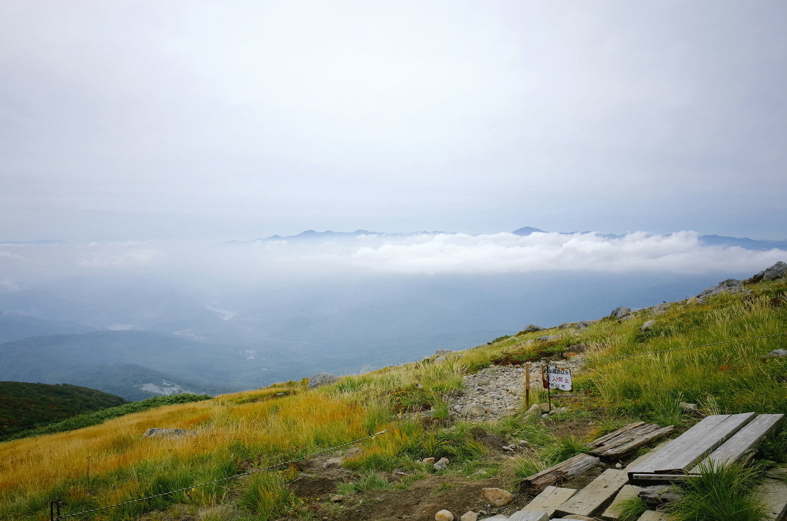 月山の登山道脇のベンチと雲海