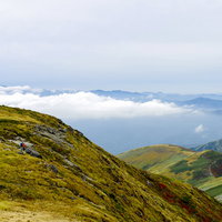 月山山頂で休憩する人々と低層の雲の写真