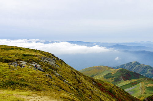 月山山頂で休憩する人々と低層の雲