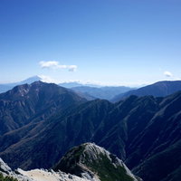 甲斐駒ヶ岳山頂から見る鳳凰山と富士山方面の山々の写真
