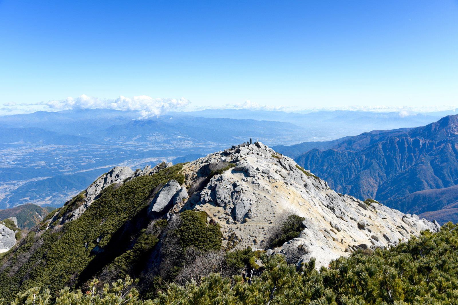 甲斐駒ヶ岳山頂から見た白砂の稜線と青空に映える山々の風景