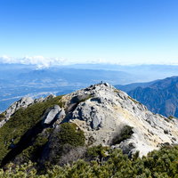 甲斐駒ヶ岳山頂から白砂の稜線を眺める雄大な山々の風景の写真