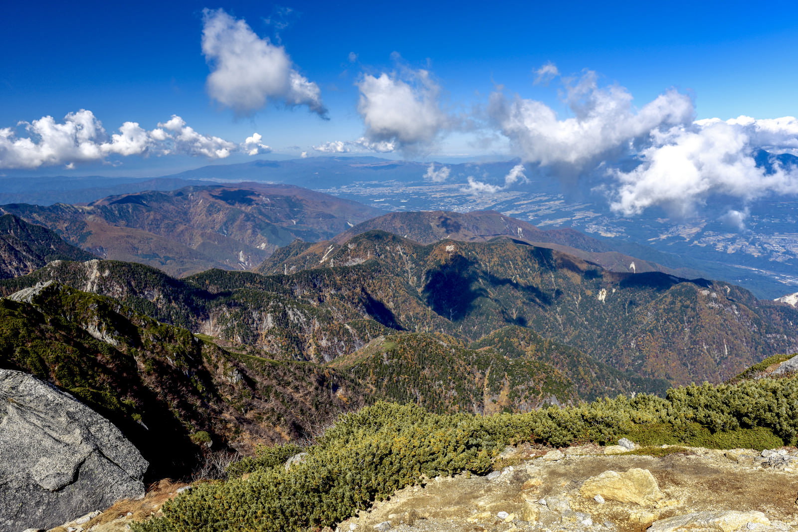 甲斐駒ヶ岳山頂から眺める紅葉した南アルプスの山々と青空