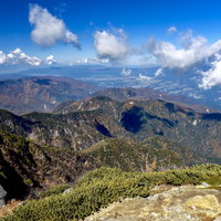 甲斐駒ヶ岳山頂から見る紅葉に染まる南アルプスの山々の写真