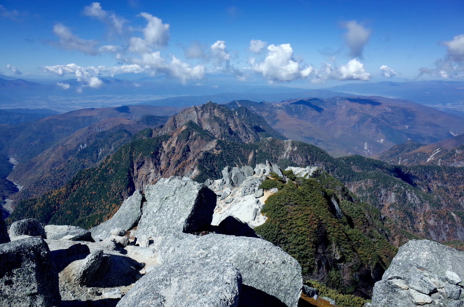 甲斐駒ヶ岳山頂から見た鋸岳の険しい岩峰群と青空に浮かぶ雲