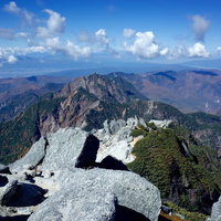 甲斐駒ヶ岳山頂から南アルプスの鋸岳を望むの写真