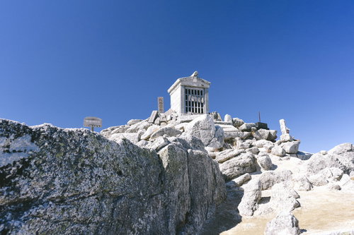 甲斐駒ヶ岳山頂の白い社と花崗岩の岩場の壮大な景観