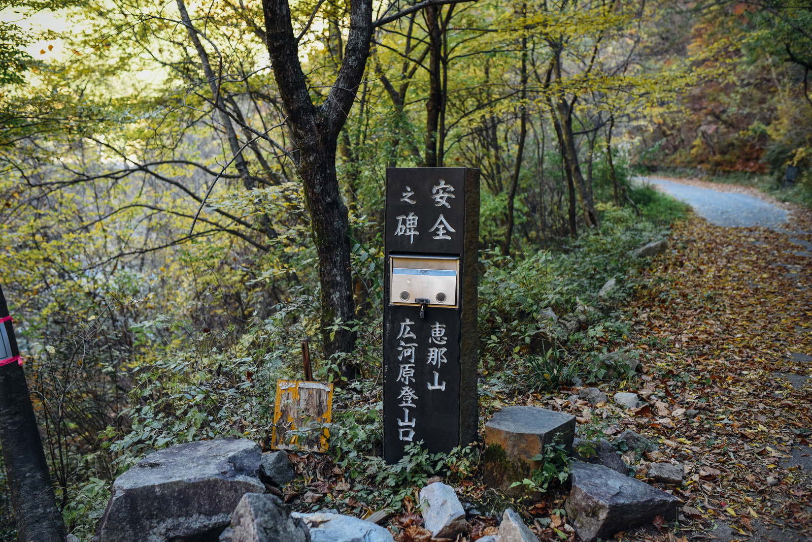 恵那山広河原登山口の石碑が新緑の森の中に立っている様子