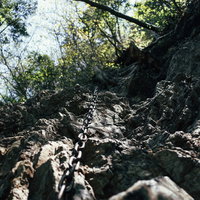 両神山八丁尾根の急峻な岩壁につけられた登山用の鎖を見上げるの写真