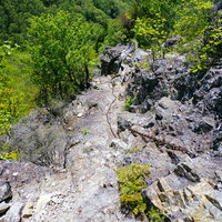 両神山の岩場に這う登山用の鎖と岩壁の風景の写真