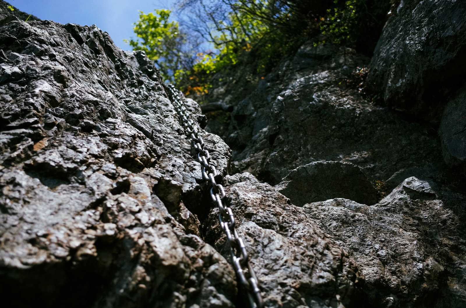 両神山の絶壁に設置された登山用の鎖が岩壁に沿って延びている