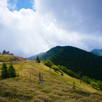雲間から光が差し込む大菩薩嶺の稜線と登山道の写真