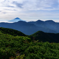 富士見平から見る赤石岳と遠景の富士山、南アルプスの山々の写真