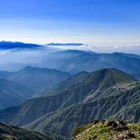 薄雲に包まれる西黒尾根から見る谷川岳、ロープウェイと稜線の写真
