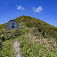 谷川岳の避難小屋と山頂へと続く登山道の景観の写真