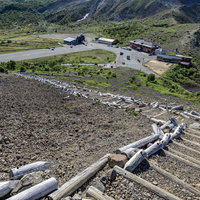 吾妻小富士から見下ろす浄土平ビジターセンターと登山道の階段の写真