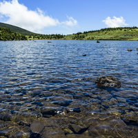 青空が映り込む吾妻連峰の山上の湖の写真